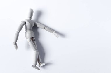 Hafif bir arka planda yan yatmış tahtadan bir adamın soyut figürü. Kopi uzayının hafif arka planında tahta bir adam figürü.