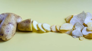 Patatesleri cips yapma fikri, fast food 'a olumsuz yaklaşım. Patates, patates dilimleri ve kıvrımlı cipsler sarı arka planda yakın plan..