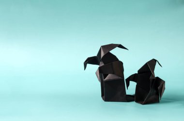 Madenin mavi arka planında iki siyah hayalet. Kağıttan yapılmış Cadılar Bayramı Hayaletleri