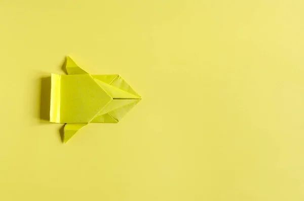 Concept paper car in yellow color on a bright yellow background close-up. Origami colored paper racing cars