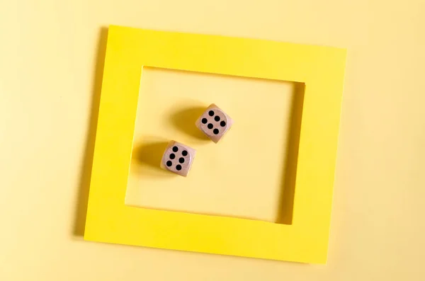 Colored frame, with dice on a colored background of the copy space. Flat ley bright yellow frame and cubes with numbers