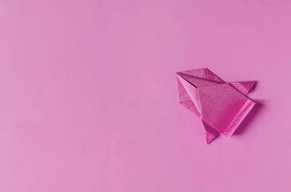 A conceptual paper car in red color on a red background of the copy space. Racing car made of colored origami paper