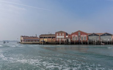 Venice, Italy - February, 2020 The bright rays of the rising sun illuminate residential buildings located on the very coast of the island. Canals are streets for movement.