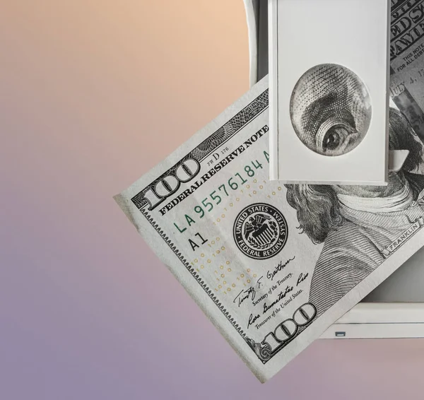 Orijinallik için parayı kontrol ediyorum. Benjamin Franklin 100 dolarlık banknotta çerçeveye özel bir cihazın büyüteçinden bakıyor. Gradyan arkaplan ve boş alan.