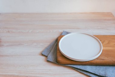 Tabak tahtada, gri mavi havlu açık bir masada ve beyaz duvar İskandinav tarzı.