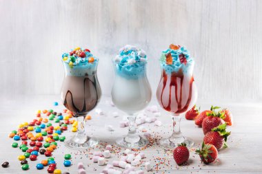 Üç çilekli milkshake, marşmelov ve şekerli.