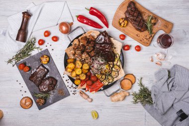 Süslü ve patatesli yuvarlak tabakta çeşitli et ve kebaplar.