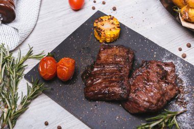 Siyah bir taşın üzerinde iki domuz eti veya biftek.