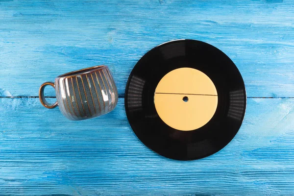 Una Taza Vacía Disco Vinilo Sobre Fondo Azul Mesa Madera — Foto de Stock