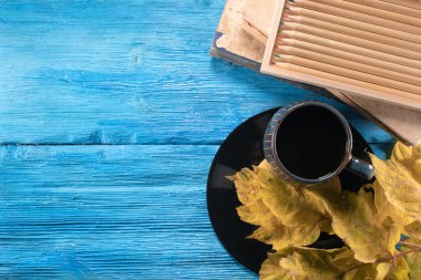Siyah kahve fincanı, kalemler, kitaplar ve mavi masanın üzerine düşmüş akçaağaç yaprakları. Kopyalama alanı olan sonbahar arkaplanı. Eğitim geçmişi.