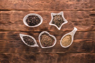 Kahverengi masa zemininde çeşitli kurutulmuş çay yaprakları var..