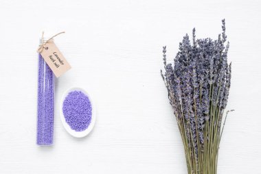 Plastik tüpte lavanta banyosu ve beyaz arka planda kurutulmuş lavanta çiçekleri..
