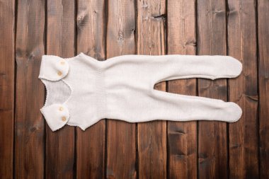 Eskimiş beyaz çocuklar kahverengi tahta masa zemininde zıplıyorlar.