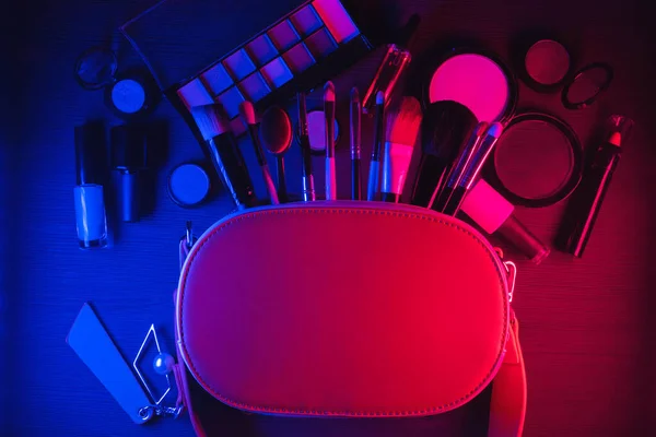 Various makeup accessories and cosmetics on the flat lay table background.