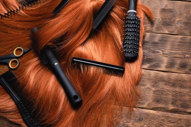 Kuaför salonu konsepti. Kızıl saçlı kadınlar kuaför masasının arka planında peruk ve tarak kullanırlar..