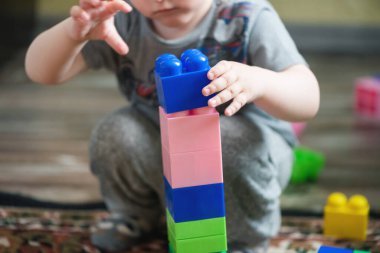 Küçük bir çocuk, bir çocuk oyuncağıyla oynuyor..