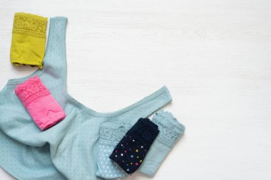 Beyaz masa arkasında kadın külotu ve gömlek var..