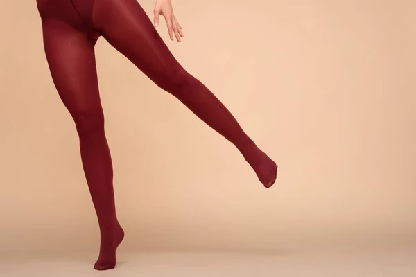 在更衣室的浅色背景上穿着红色长袜的女性腿 — 图库照片