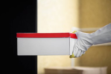 Lastik eldivenli, karton kutulu kadın elleri..