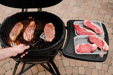 Seçici odaklanma. Izgarada ızgara biftek. Geleceğin bifteği ve barbeküsü. Izgara arka planında et. 