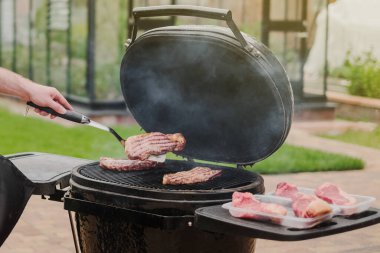 Seçici odaklanma. Izgarada ızgara biftek. Geleceğin bifteği ve barbeküsü. Izgara arka planında et. 