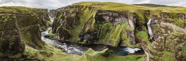 Una gola e un canyon Fjadrargljufur in Islanda. Fotografia panoramica. Il concetto di cartoline e viaggi. Erba verde e scogliere pittoresche. — Foto Stock