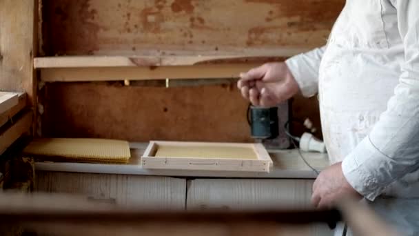 Preparing a wax frame for beehings with bees. The theme of beekeeping and honey. Close-up of the beekeepers hands. creating and fixing wax frames for bees. electric welding. — Stock Video