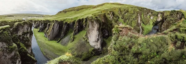 En ravin och en kanjon Fjadrargljufur på Island. Panoramafotografering. Begreppet vykort och resor. Grönt gräs och pittoreska klippor. — Stockfoto