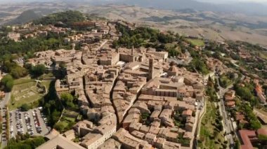 İtalya 'nın Toskana kentindeki Volterra kasabasının pitoresk bir manzarası. Şehrin panorama 'sı kuş bakışı. Dar sokaklar ve kiremit ve fayanslardan yapılmış çatılar. Seyahat İtalyan konsepti. Drone videosu.