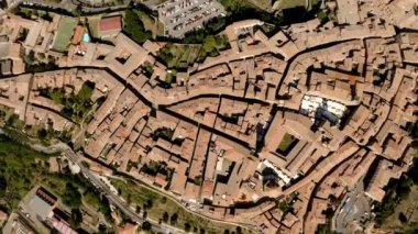 İtalya 'nın Toskana kentindeki Volterra kasabasının pitoresk bir manzarası. Şehrin panorama 'sı kuş bakışı. Dar sokaklar ve kiremit ve fayanslardan yapılmış çatılar. Seyahat İtalyan konsepti. Drone videosu.