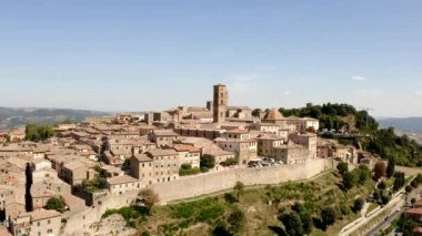 İtalya 'nın Toskana kentindeki Volterra kasabasının pitoresk bir manzarası. Şehrin panorama 'sı kuş bakışı. Dar sokaklar ve kiremit ve fayanslardan yapılmış çatılar. Seyahat İtalyan konsepti. Drone videosu.