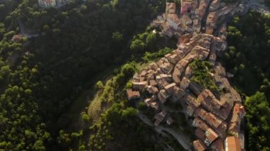 Scansano kasabası yukarıdan. Havadan güzel bir manzara. Geometrik sokaklar ve yollar. Tepelerde kiremitli çatılar ve ağaçlar. İtalya, Toskana 'da küçük bir şehir. İnsansız hava aracından görüntüle. 