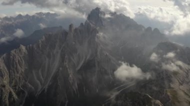 Bulutların muhteşem manzarası ve İtalyan dolomit Alpleri. Dağ sırası ve turizm teması. Manzara ve geniş ölçekli kuş bakışı manzara. İnsansız hava aracı görüntüleri.