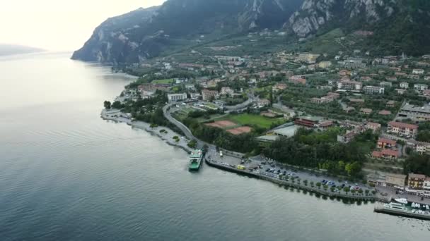 Limone Sul Garda ville sur le lac de Garde, Italie. Belle vue aérienne panoramique sur la ville et les montagnes. Eau de lagune et ciel. Promenade et bâtiments au bord de l'eau. — Video