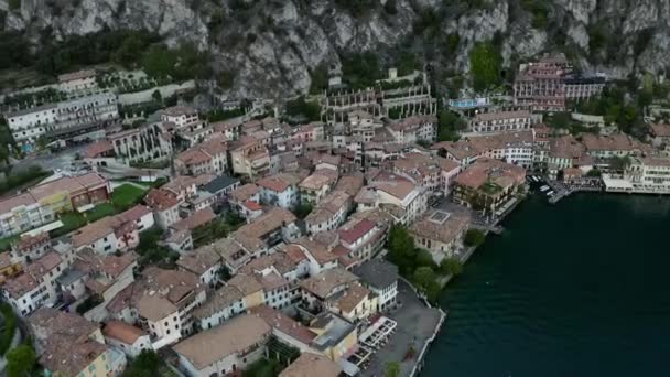 Limone Sul Garda ciudad en el lago de Garda, Italia. Hermosa vista panorámica aérea a la ciudad y las montañas. Agua de laguna y cielo. Paseo marítimo y edificios en el paseo marítimo. — Vídeos de Stock