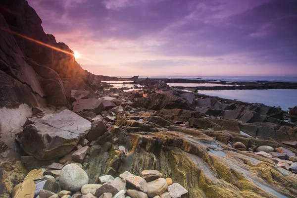 Na pobřeží Sunrise v rock — Stock fotografie