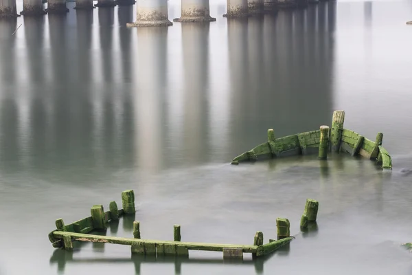 A sunken ship next to the bridge pier — Stock Photo, Image