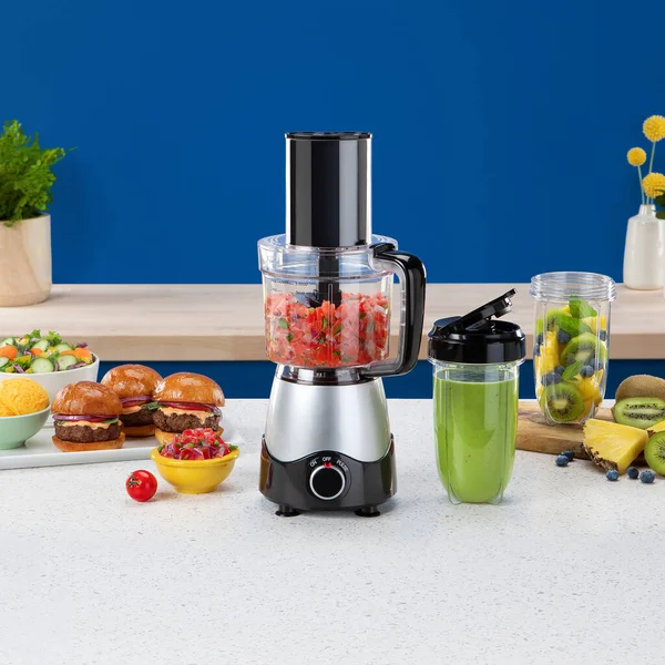 Blender with vegetables and fruit smoothies on a kitchen table