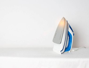 Giysilerin kıvrımlarını yumuşatmak için alüminyum tabanlı modern bir demir. Sıcak ve tehlikeli demir taban kavramı, yangın tehlikesi, metin için kopyalama alanı