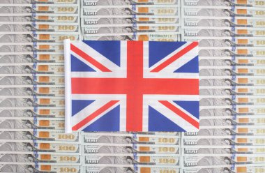 Dolar banknotlarının arka planında Birleşik Krallık bayrağı var. İngiliz parasının dolar, ülke ekonomisi ve finansal ilişkisine ilişkin kavramı