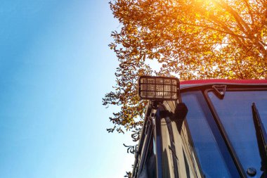 Trafik güvenliği ve aydınlatma için traktördeki arka ışıklar sonbahar ağacı ve mavi gökyüzünün arka planına karşı. Metin ve teknoloji için alanı kopyala