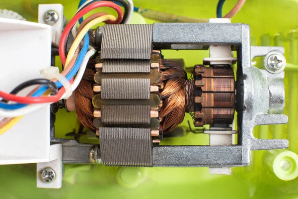 Broken electric motor in a household appliance hand mixer. Malfunction of the rotor and stator of electrical components, close-up, Engineering