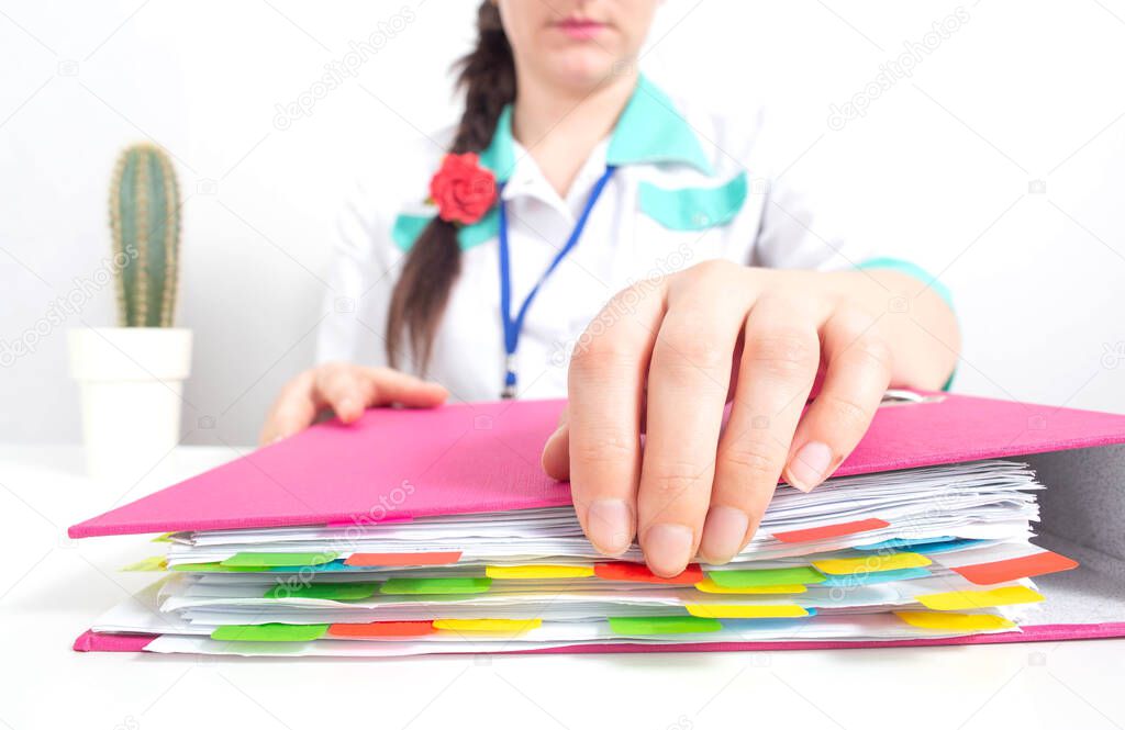 A medical worker opens a folder for accounting documents and cost estimates for medical materials for covid-19