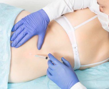 Doktor bir kız hasta için bel omurgasında paravertebral tıbbî abluka yapıyor. Omurga hastalıkları ve siyatik sinirlerin ihlali için ağrı kesici kavramı.