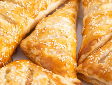 Susamlı, jambonlu ve peynirli nefis çıtır börekler. Lezzetli yemekler, arka plan. Maya hamuru, geleneksel