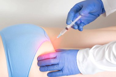 Doktor, hastaya siyatik sinir kalça bölgesinde ilaç ablukası uyguluyor. Ağrıyı ve iltihaplanmayı ortadan kaldırmak için ilaç ablukasındaki karmaşık ilaç ürünleri kavramı