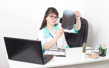 Doctor andrologist examines an x-ray picture of the spine. Arthritis and gout treatment, background. Medical clinic clipart