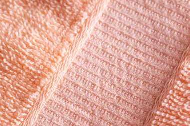 Soft peach-colored fleecy fabric. Orange fabric background, macro