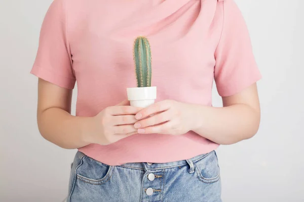 Girl holding a cactus on the background of the stomach. Stitching abdominal pain concept. Gastritis and stomach ulcers