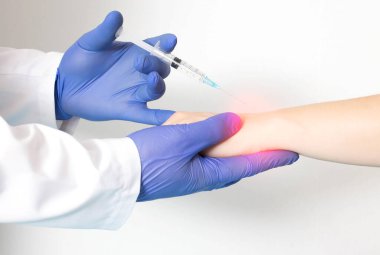 Bir doktor romatolog eklemlerinde ağrı ve iltihap olan bir hastaya bilek bloğu uyguluyor. Lokal anestezi ve kondrokorumacı enjekte etme kavramı, yakın plan, higroma